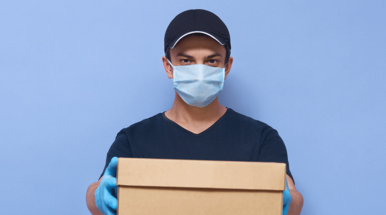 Entregador com máscara segurando uma caixa de entrega||entrega expressa ou 24h